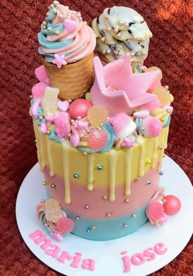 Pastel colorido decorado con helados, caramelos y detalles festivos. Ideal para fiestas.