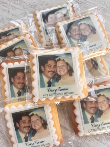 Galletas decoradas con fotos de dos personas en un fondo claro.