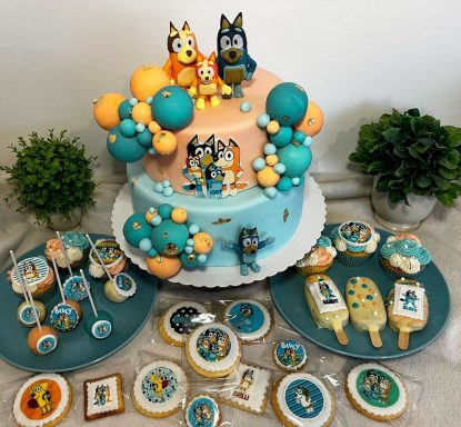 Tarta decorada con personajes de dibujos animados y galletas temáticas.