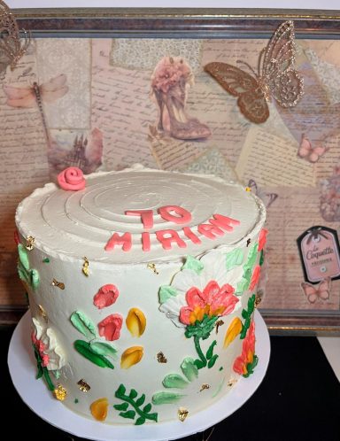 Pastel decorado con flores y un mensaje que dice "Para Miriam". Fondo con elementos vintage.