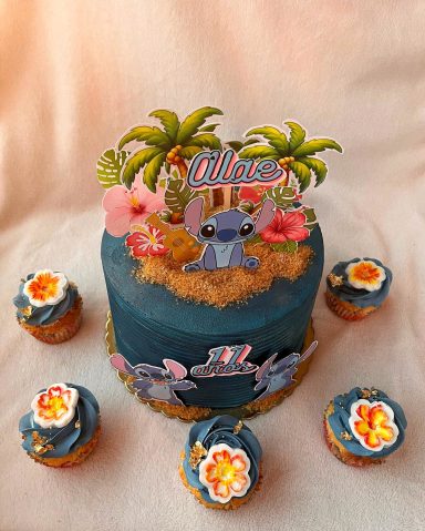 Tarta de cumpleaños con tema de "Lilo y Stitch", decorada con flores y palmeras.