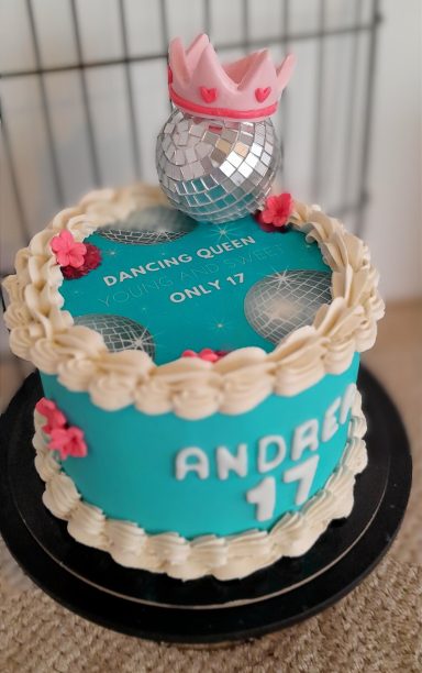 Tarta decorada en tonos azules, con flores rosadas y corona, para el cumpleaños 17.