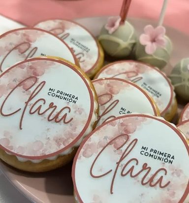 Galletas decoradas con el nombre "Clara" y pastelitos para la primera comunión.